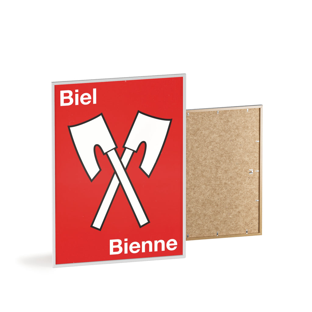 Minimalist framed wall poster of the Biel Bienne coat of arms featuring crossed white axes on a red background, displayed in a natural pinewood frame.