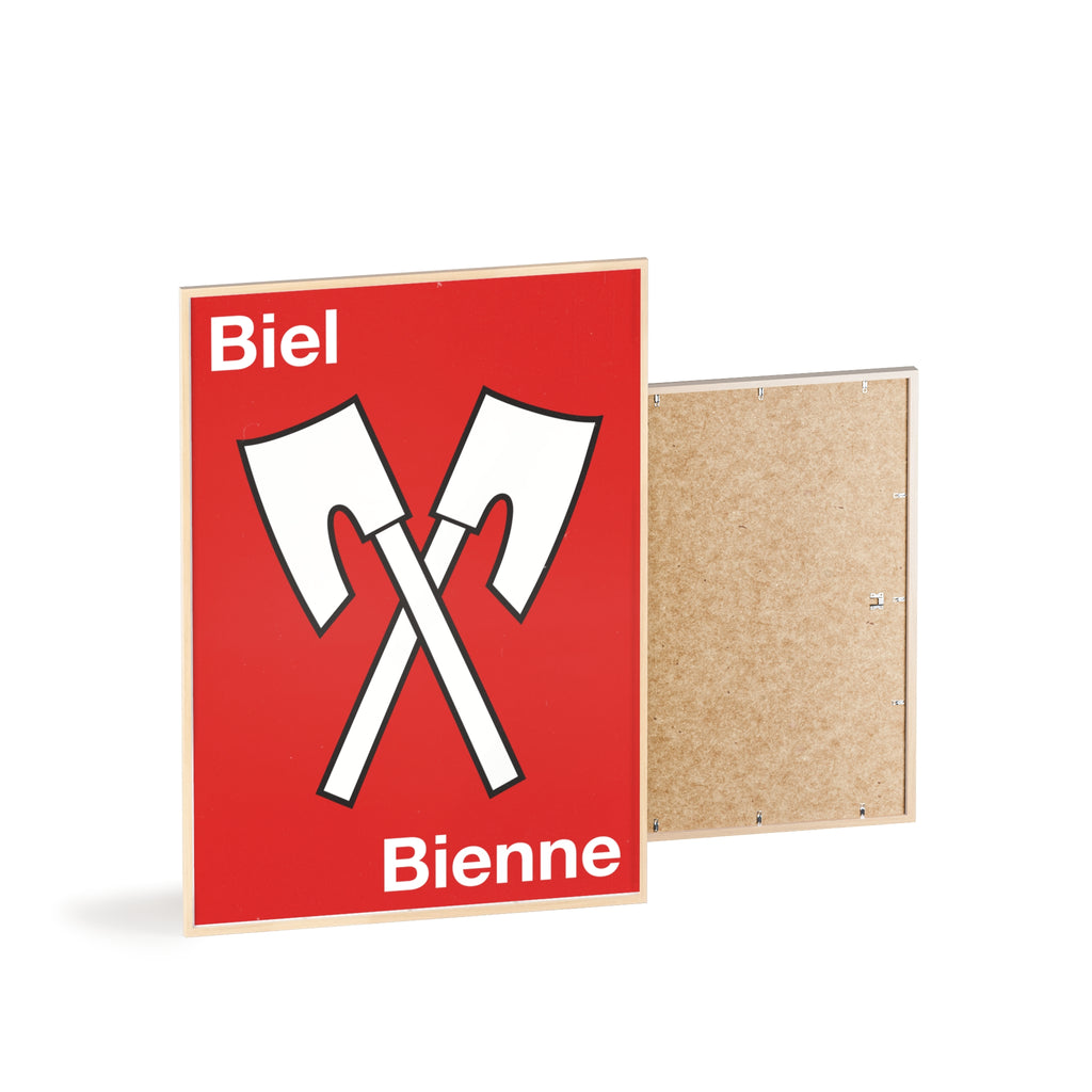 Minimalist framed wall poster of the Biel Bienne coat of arms featuring crossed white axes on a red background, displayed in a natural pinewood frame.