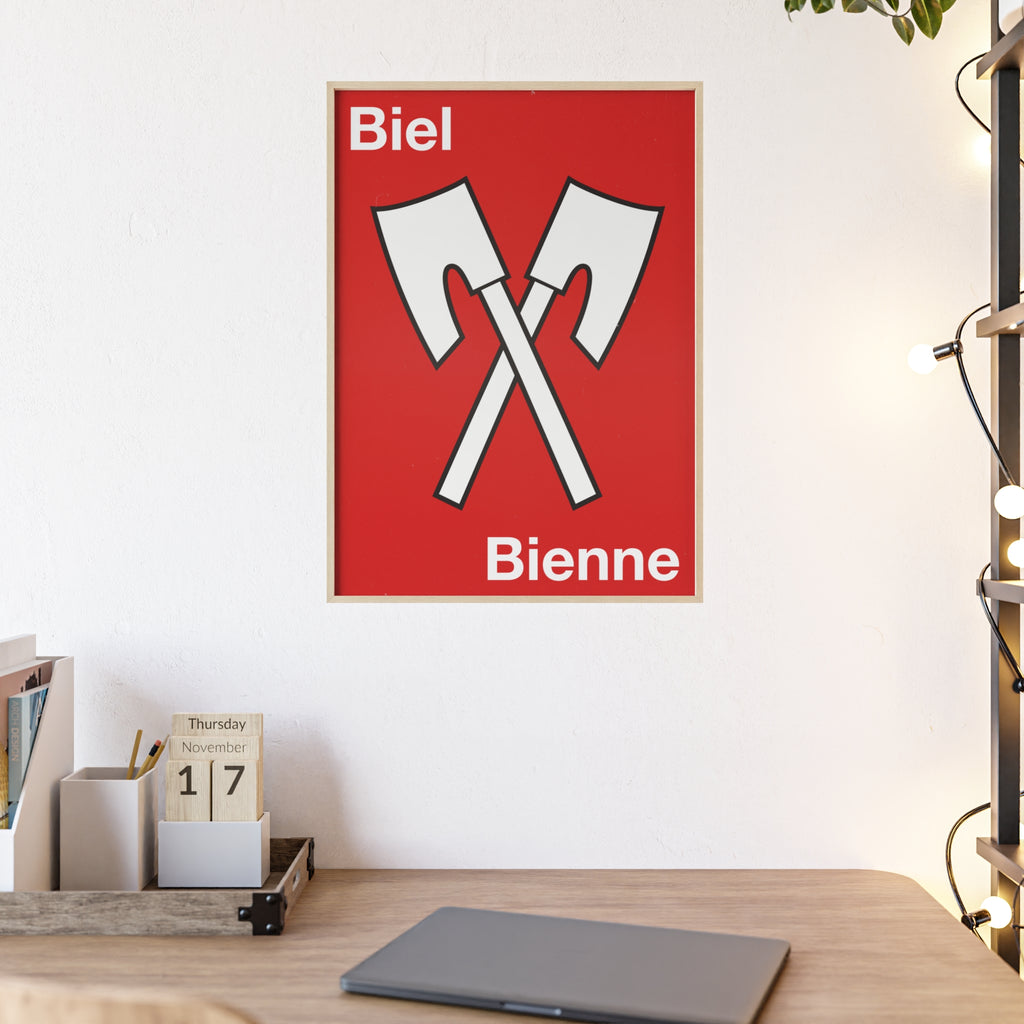 Minimalist framed wall poster of the Biel Bienne coat of arms featuring crossed white axes on a red background, displayed in a natural pinewood frame.