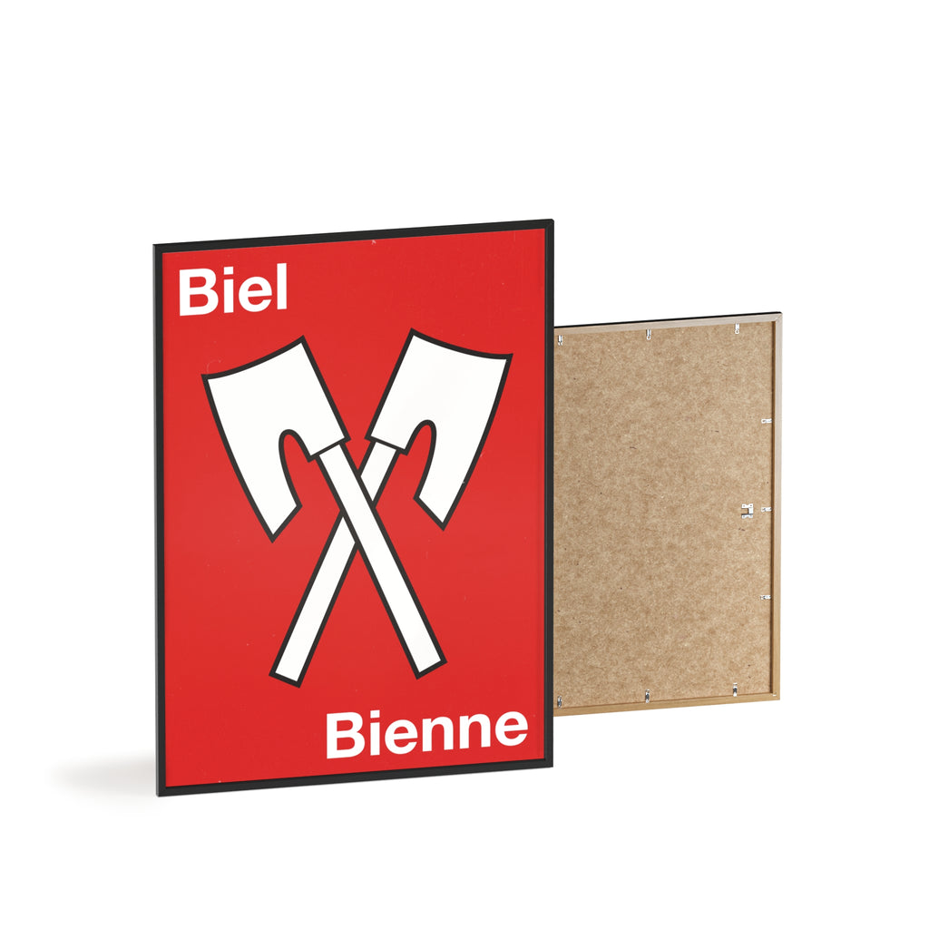 Minimalist framed wall poster of the Biel Bienne coat of arms featuring crossed white axes on a red background, displayed in a natural pinewood frame.