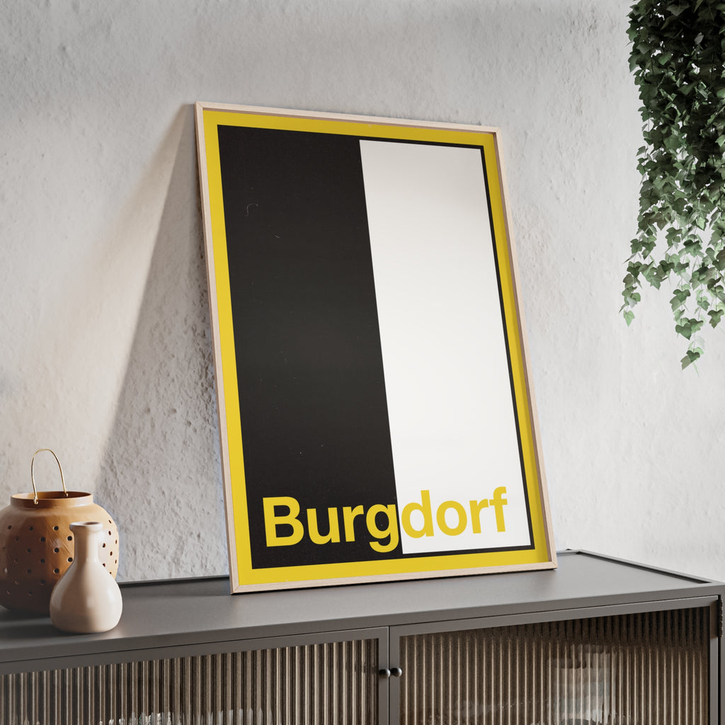 Minimalist framed wall poster of the Burgdorf coat of arms featuring vertical black and white panels with a yellow border, displayed in a natural pinewood frame.