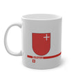 White ceramic mug featuring the red Canton of Schwyz coat of arms with a small white cross, a modern red horizontal line with 'Schwyz' text, and a small Swiss cross below.