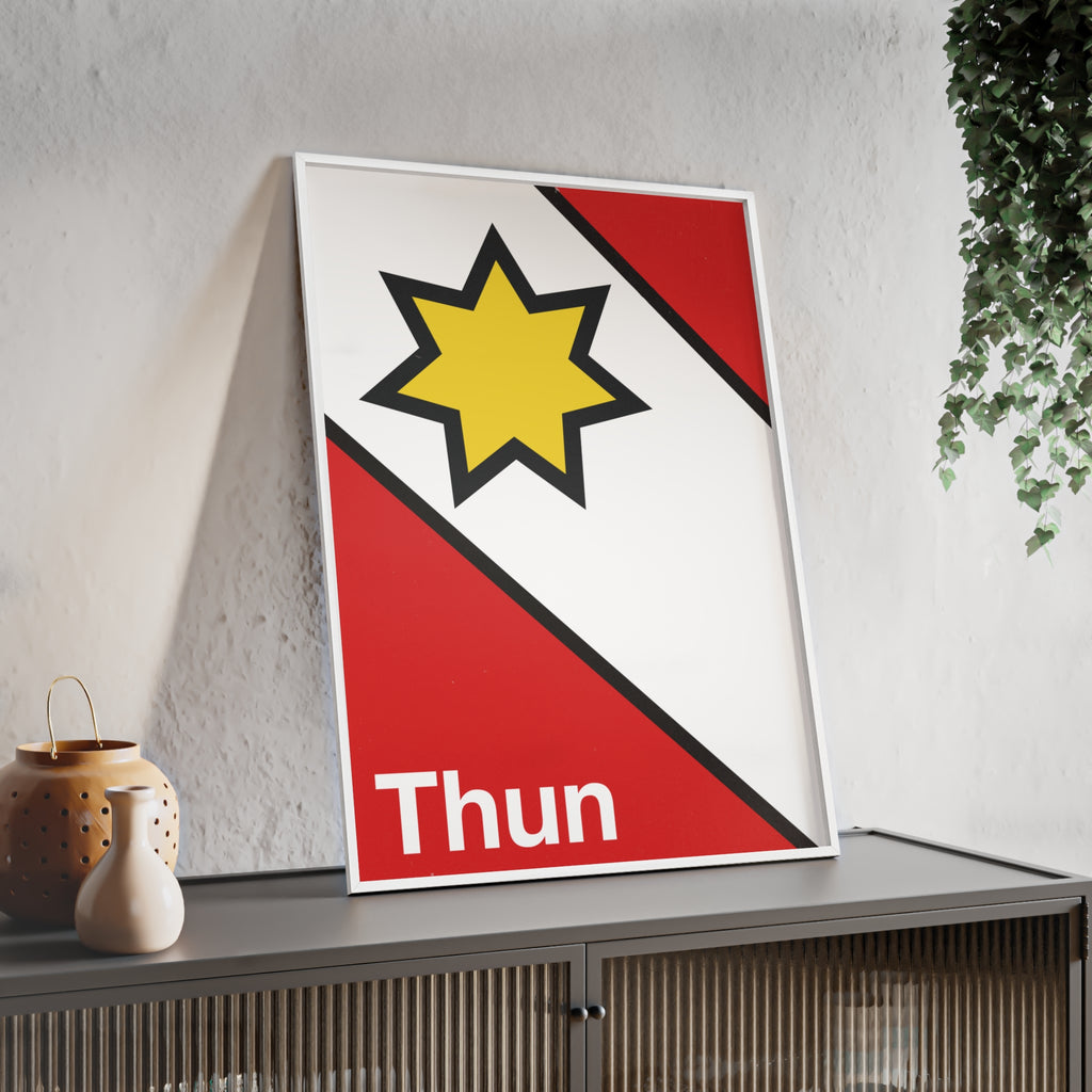 Minimalist framed poster of the Thun coat of arms featuring a yellow star on red and white diagonal fields, displayed in a natural wood frame on a console table.