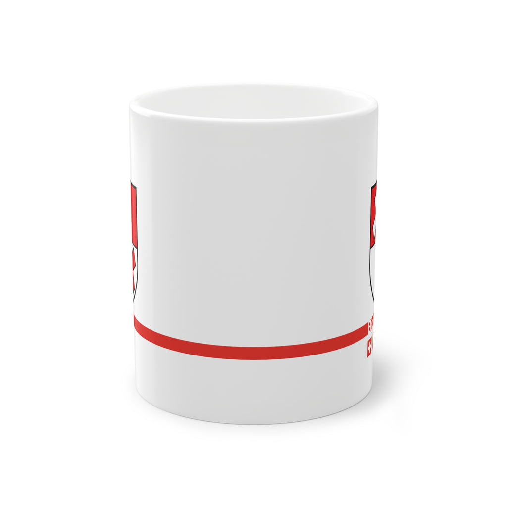 White ceramic mug featuring the red and white split coat of arms of the Biglen Commune, a modern red horizontal line with 'Biglen' text, and small Swiss and Bernese bear flags below.