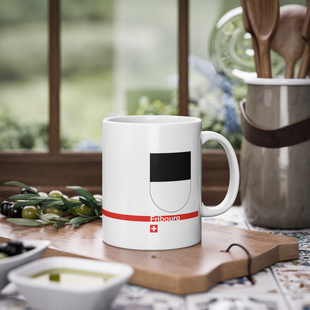 White ceramic mug with the black and white horizontally divided coat of arms of the Canton of Fribourg, Switzerland, featuring a modern red line and a small Swiss cross.