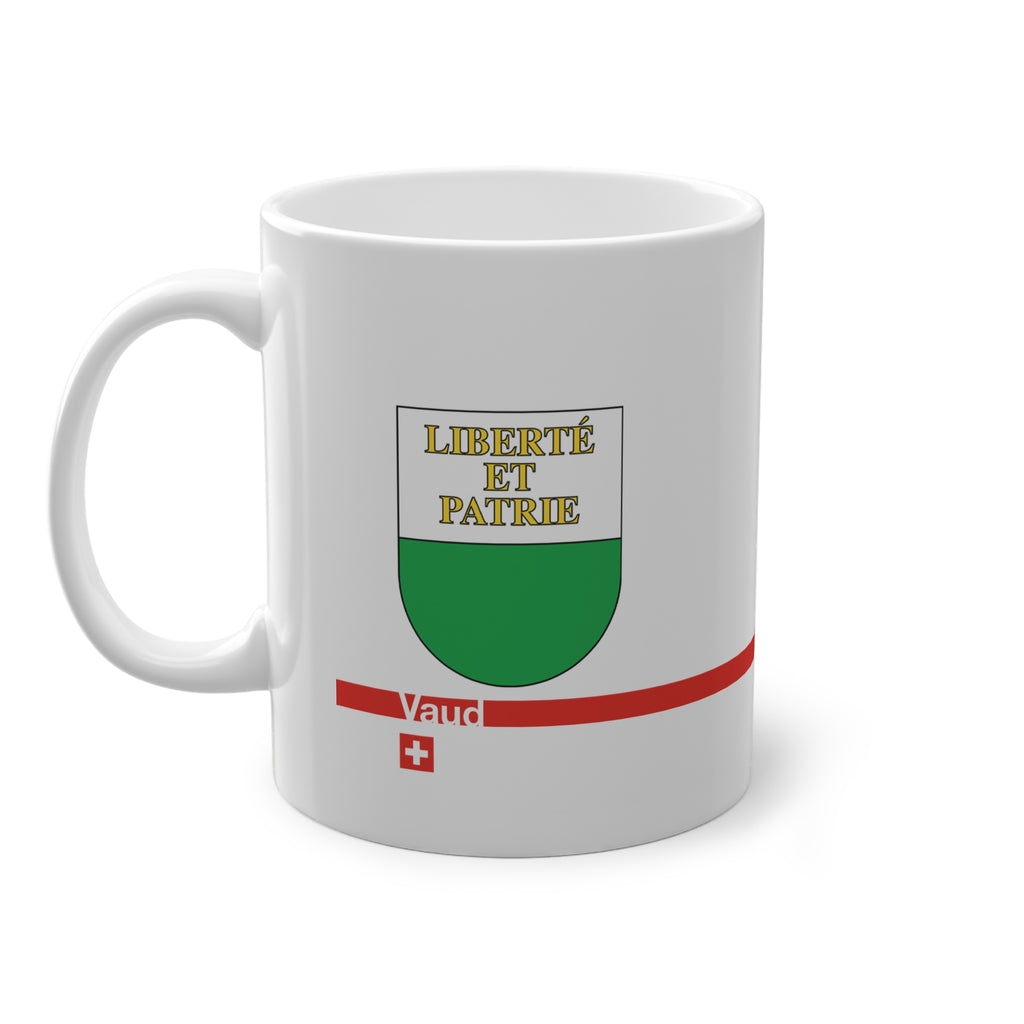 White ceramic mug featuring the white and green Canton of Vaud coat of arms with golden 'Liberté et Patrie' text, a modern red horizontal line with 'Vaud' text, and a small Swiss cross below.